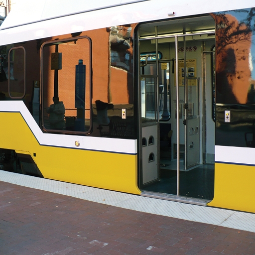 train with warning strip on pavement adjacent to it